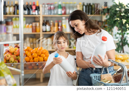Checking expiration date of milk - mother and daughter checking qr code on bottle of milk Checking expiration date of milk - mother and daughter checking qr code on bottle of milk 121140051