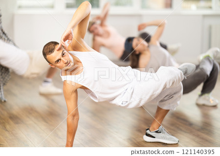 Young guy practicing breakdance in training hall Young guy practicing breakdance in training hall 121140395