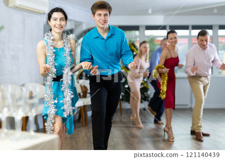 Cheerful young couple dancing Lindy Hop at Christmas celebration in office 121140439