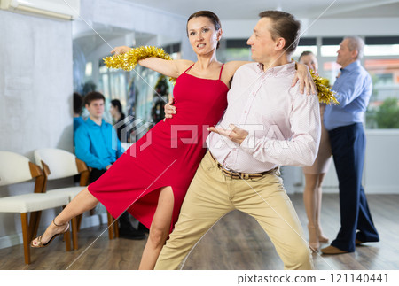 Man and woman performing support while dancing salsa at Christmas party 121140441