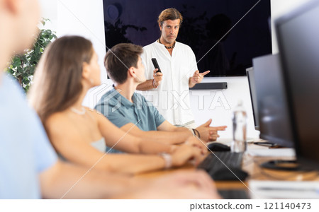 Instructor conducting software development courses to young guys and girls Instructor conducting software development courses to young guys and girls 121140473