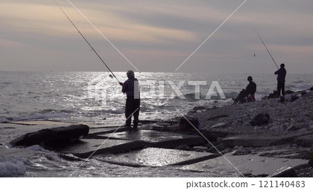 Many fishermen catch mullet fish on a spinning rod on the sea coast 121140483