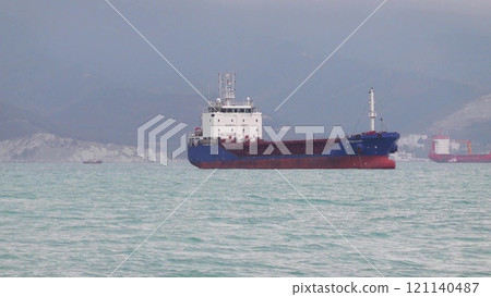 Sea freighter sailing in the middle of the ocean with big waves 121140487