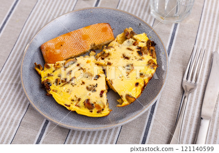 Homemade breakfast or brunch meal - Tasty mushroom omlette on plate, overhead view. Homemade breakfast or brunch meal - Tasty mushroom omlette on plate, overhead view. 121140599
