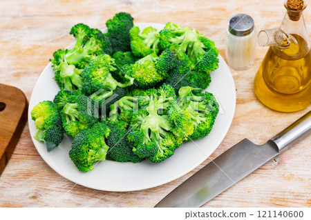 Florets of fresh raw broccoli on plate with oil and spices Florets of fresh raw broccoli on plate with oil and spices 121140600