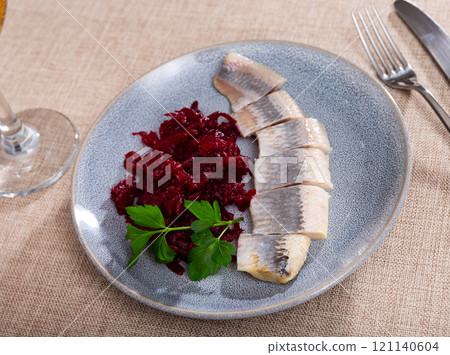 On round blue plate - lightly salted herring fillet cut into pieces with stewed beets 121140604
