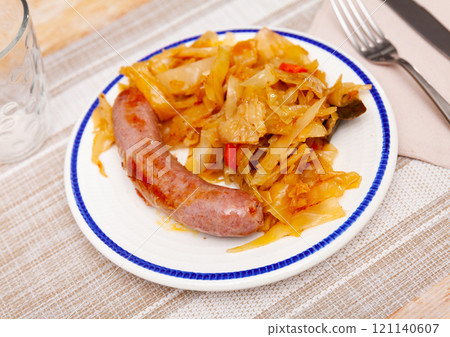 Fried small fatty sausage and stewed shredded cabbage . 121140607