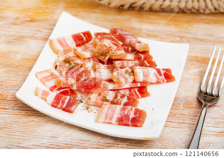 Brine cured pork belly slices with seasonings 121140656