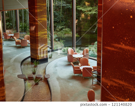 A spacious hotel lobby with chairs, large windows and a garden view in the morning 121140820