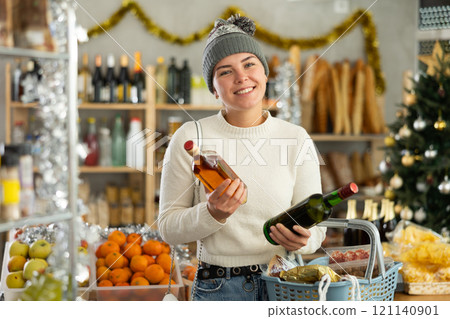 Preparing for Christmas celebration - girl buys bottle of whiskey in grocery shop Preparing for Christmas celebration - girl buys bottle of whiskey in grocery shop 121140901