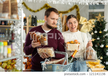 Man and a woman choose sweets for Christmas Man and a woman choose sweets for Christmas 121141136