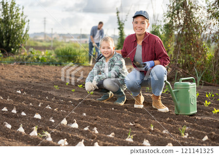 Woman and her son plant seeds 121141325