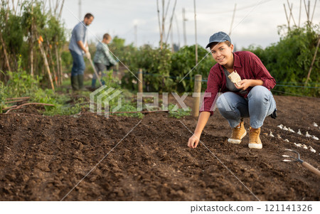 Female farmer planting seeds in the garden Female farmer planting seeds in the garden 121141326