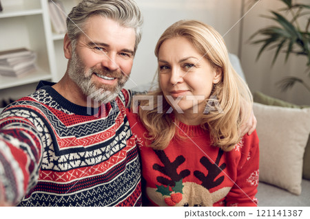 Waist up of a happy mature couple making selfie 121141387