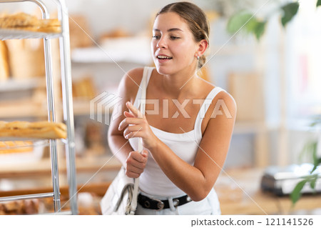 Young woman looking around in bakery Young woman looking around in bakery 121141526