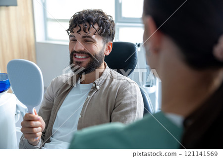 Man patient during whitening teeth procedures in modern dental clinic Man patient during whitening teeth procedures in modern dental clinic 121141569