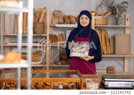 Saleswoman with a box of cookies in a supermarket Saleswoman with a box of cookies in a supermarket 121141742