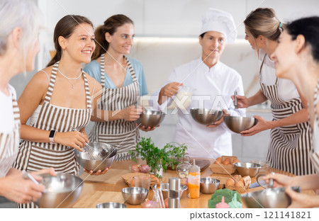 Young female visitor has nice conversation with person facing buddy vis-a-vis at culinary courses Young female visitor has nice conversation with person facing buddy vis-a-vis at culinary courses 121141821