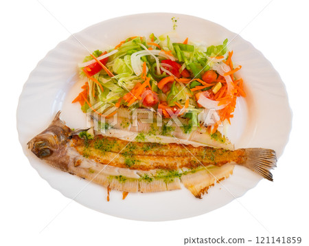 There is plate with fried solea flatfish and salad of fresh veg on wooden table. There is plate with fried solea flatfish and salad of fresh veg on wooden table. 121141859
