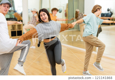 Emotional brunette teenage girl learning to dance lindy hop in pair with boy Emotional brunette teenage girl learning to dance lindy hop in pair with boy 121141868