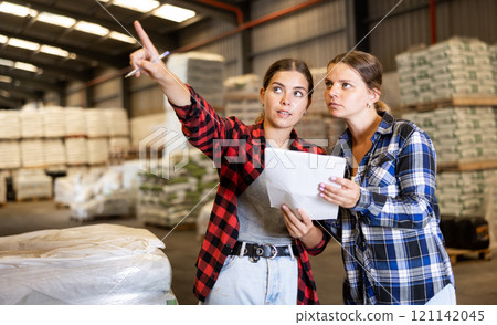 Women working in warehouse, talking about job Women working in warehouse, talking about job 121142045