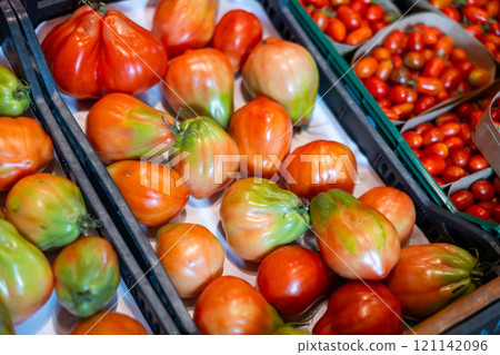 Pile of tomatoes lie on counter in shop Pile of tomatoes lie on counter in shop 121142096
