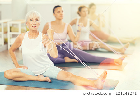 Elderly woman exercising with pilates loop Elderly woman exercising with pilates loop 121142271