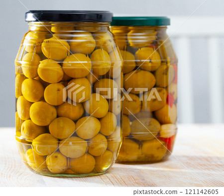 Glass jar with delicious whole olives at wooden table Glass jar with delicious whole olives at wooden table 121142605