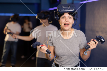 girl is exhilarated by turn of events in VR game and moved virtual reality glasses to forehead 121142730