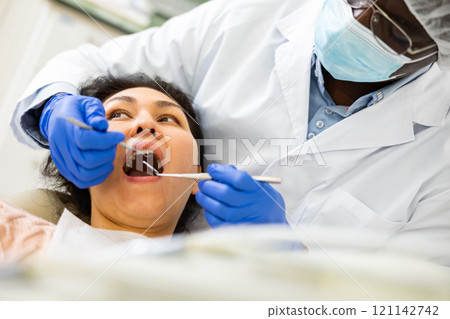 Orthodontist using tools and curing toothache of asian woman Orthodontist using tools and curing toothache of asian woman 121142742