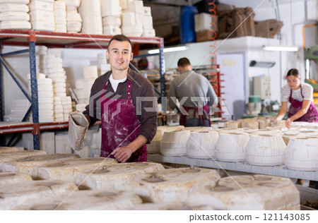 Potter filling casting molds with slip to shape ceramic products 121143085