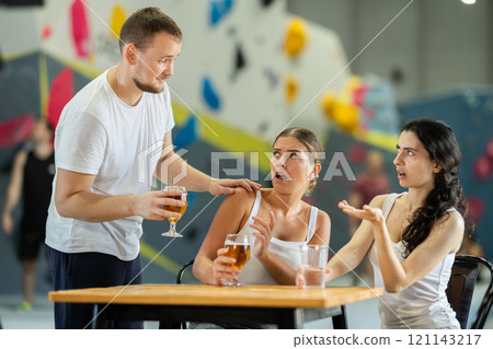 Man tries to talk to two angry women on climbing wall Man tries to talk to two angry women on climbing wall 121143217