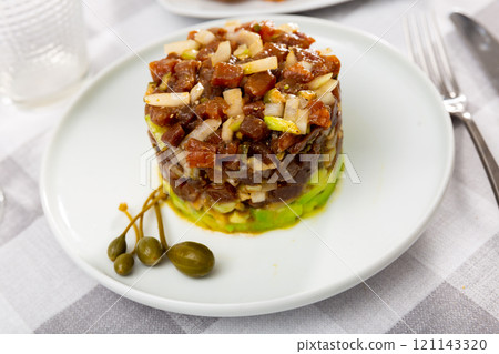 Tasty tuna tartare with avocado and quinoa on plate in restaurant 121143320