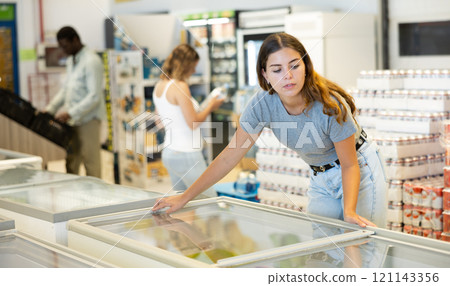 Young woman choosing frozen food in supermarket 121143356