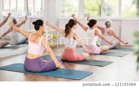 Group of women exercising with pilates loop back view 121143369