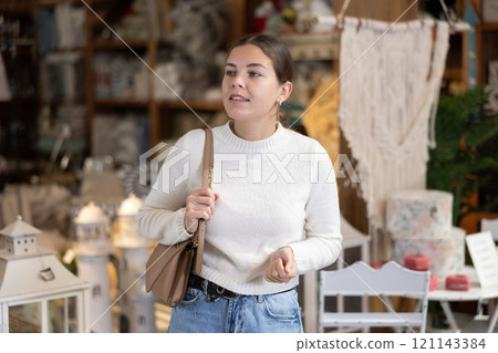 Young woman choosing furniture in store Young woman choosing furniture in store 121143384