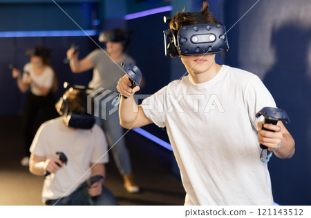 Portrait of young man with virtual reality glasses standing in room Portrait of young man with virtual reality glasses standing in room 121143512