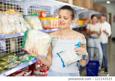 Asian girl chooses traditional Chinese noodles in supermarket 121143525