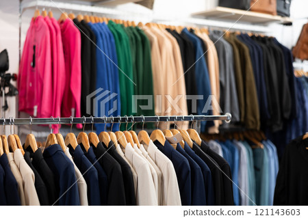 Assortment of winter and autumn clothing in garment store interior 121143603