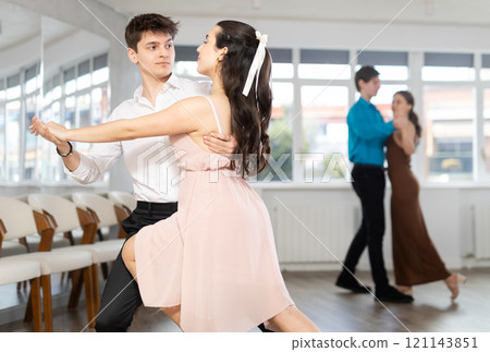 Hispanic guy practicing bachata with young brunette in dance class 121143851