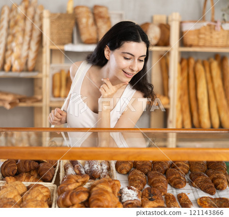 Young woman choosing pastries in bakery 121143866