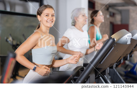 Girl in sportswear are running on treadmill Girl in sportswear are running on treadmill 121143944