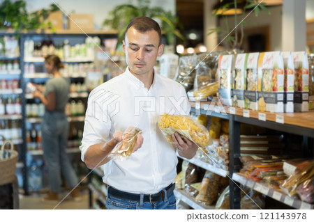 Young man purchaser buying pasta in grocery store 121143978