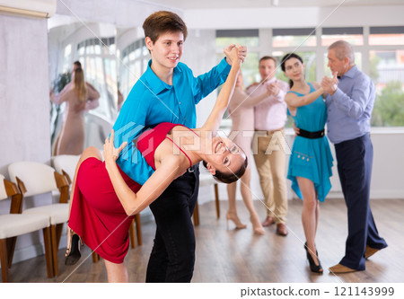 Young couple performing dip move while dancing in salsa class Young couple performing dip move while dancing in salsa class 121143999