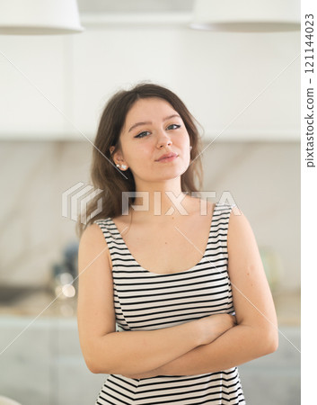 Young smiling woman in kitchen Young smiling woman in kitchen 121144023