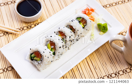 Set of uramaki rolls with salmon, avoado and cucumber closeup Set of uramaki rolls with salmon, avoado and cucumber closeup 121144063