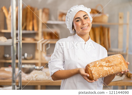 Young saleswoman displaying fresh sourdough bread Young saleswoman displaying fresh sourdough bread 121144090