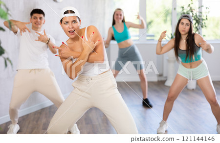 Young girl krumper dancing with group of teenagers in studio 121144146