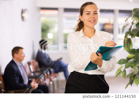 Happy young woman standing with her back to waiting room Happy young woman standing with her back to waiting room 121144150