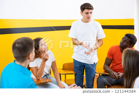 Group of young students studying in university with male tutor 121144384